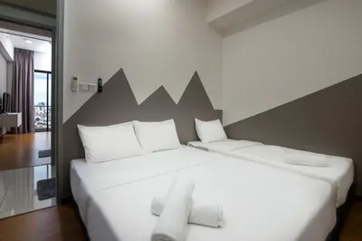 a bedroom with a white bed with a large headboard at Penang KTHOME Beacon Executives suite in George Town
