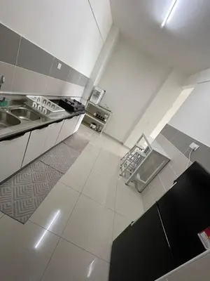 a large white kitchen with a sink and a counter at Rumah Puteh Homestay in Ipoh