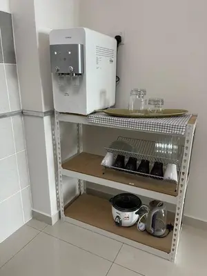 a microwave sitting on a shelf in a kitchen at Rumah Puteh Homestay in Ipoh