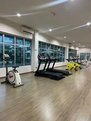 a gym with several treadmills and exercise bikes at Rumah Puteh Homestay in Ipoh