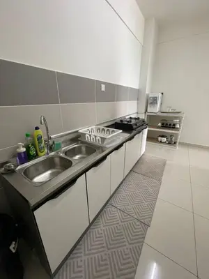 a kitchen with a sink and a stove at Rumah Puteh Homestay in Ipoh