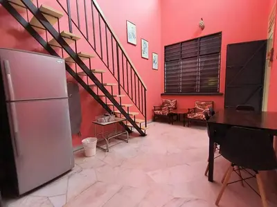 a room with a staircase and a table and a refrigerator at Wi-Fi 100MB Free Ipoh Happy Big House SemiD TH24 16 pax in Ipoh