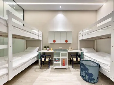 a room with two bunk beds and a table and chairs at Designer Guesthouse Pulau Tikus & Gurney Drive, Georgetown, Penang in George Town