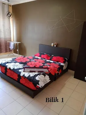 a bedroom with a bed with a colorful quilt at Hakimi Homestay in Tanah Rata