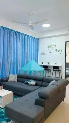 a living room with a couch and blue curtains at Ocean Home@Urban Suites@12 Pax in Jelutong