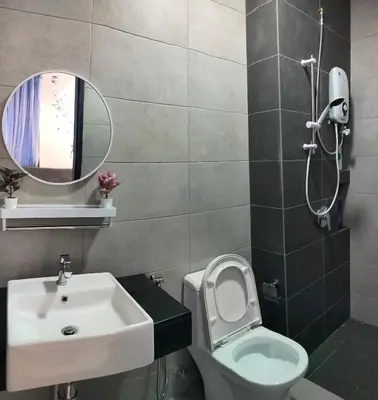 a bathroom with a sink and a toilet and a mirror at Ocean Home@Urban Suites@12 Pax in Jelutong