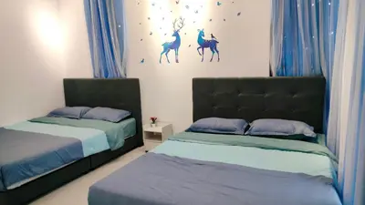 two beds in a bedroom with blue curtains at Ocean Home@Urban Suites@12 Pax in Jelutong