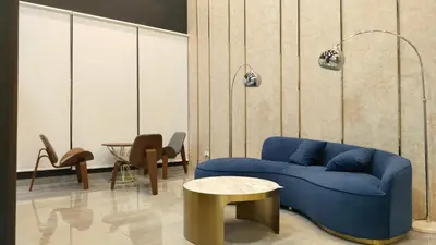 a living room with a blue couch and a table at Ocean Home@Urban Suites@12 Pax in Jelutong