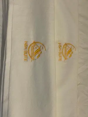 two logos on a white towel on a bed at IPOH TAMBUN THE COVE Your Ultimate Relaxation Getaway777 -3 BED ROOM -NO PETS ALLOW in Ipoh