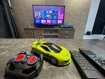a remote control car sitting on a table next to a tv at 3 Room/3 Queen Bed, Urban Suite Arcade Room #2carpark in Jelutong