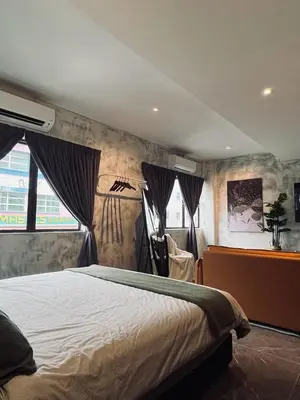 a bedroom with a bed with curtains on the wall at The Ash Ipoh - Family Suite in Ipoh