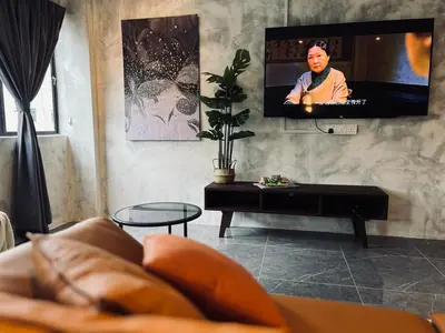 a living room with a couch and a flat screen tv at The Ash Ipoh - Family Suite in Ipoh