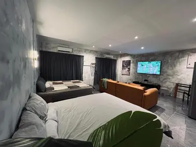 a bedroom with a bed and a television in it at The Ash Ipoh - Family Suite in Ipoh