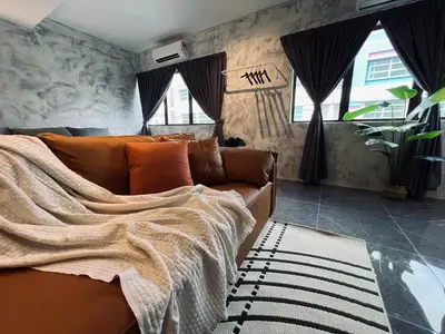 a living room with a couch with a blanket on it at The Ash Ipoh - Family Suite in Ipoh