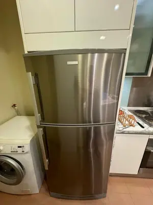 a stainless steel refrigerator in a kitchen next to a washing machine at Perfect Marina @ Strait Quay /w Exclusive Stay in Tanjong Tokong