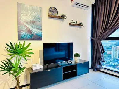 a living room with a tv and a clock on the wall at New URBAN SUITES Seaview Family Homestay by Urban Staycation HENG LOD COSY in Jelutong