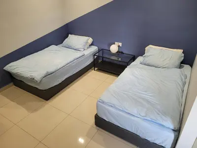 two beds in a room with a blue wall at Venus Cozy Home in Seri Manjung