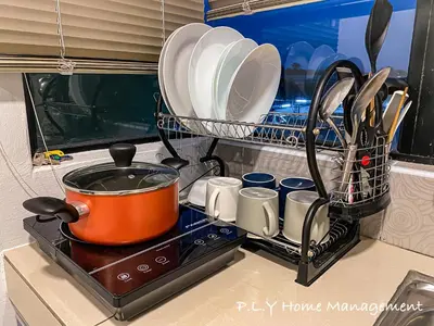 a pot on a stove with plates and utensils at Crystal Cozy Suite PoolView Netflix Waterpark@ Ipoh Station 18 in Ipoh