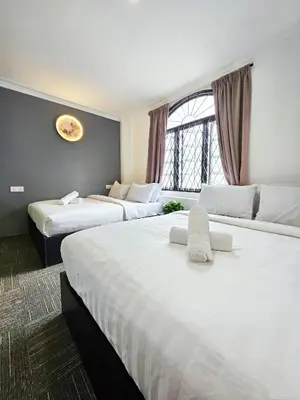 two beds in a hotel room with white sheets at Luna Hotel by Moonknight in George Town