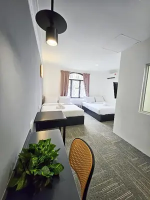 a room with two beds and a table and chairs at Luna Hotel by Moonknight in George Town