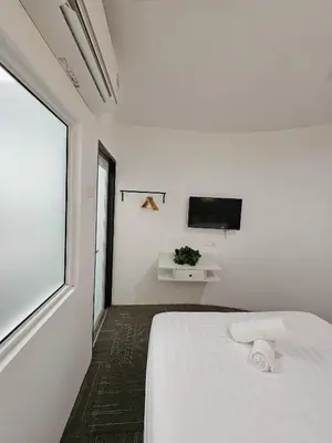 a white bedroom with a bed and a tv at Luna Hotel by Moonknight in George Town