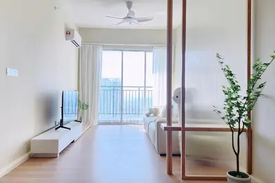 a living room with a couch and a television at Home Cinema - BM City Centre - 4km to Icon City at The Metropol Muji Style Apartment in Bukit Mertajam