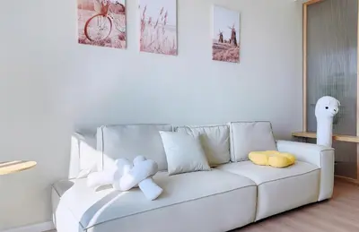 a white couch with stuffed animals on it in a living room at Home Cinema - BM City Centre - 4km to Icon City at The Metropol Muji Style Apartment in Bukit Mertajam