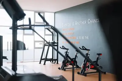 a gym with two treadmills and two exercise bikes at Home Cinema - BM City Centre - 4km to Icon City at The Metropol Muji Style Apartment in Bukit Mertajam