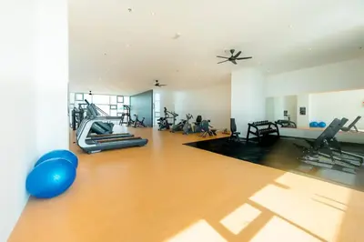 a gym with people exercising on machines in a room at Home Cinema - BM City Centre - 4km to Icon City at The Metropol Muji Style Apartment in Bukit Mertajam