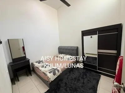 a bedroom with a bed and a dresser and a mirror at AISY HOMESTAY KULIM/LUNAS in Kulim