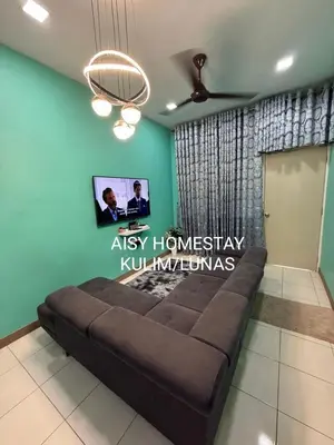 a couch in a room with a green wall at AISY HOMESTAY KULIM/LUNAS in Kulim