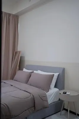 a bed sitting in a room with a table at Urban Suites Homestay by Vista Vibes in Jelutong