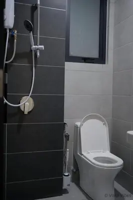 a small bathroom with a toilet and a shower at Urban Suites Homestay by Vista Vibes in Jelutong