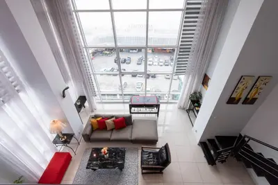 a living room with a couch and a large window at Karaoke,XBox,Foosball,Billiard,Air Hockey,Ping Pong & Board Games in George Town