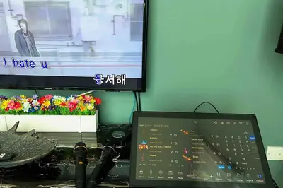 a desk with a laptop computer and a tv at Karaoke,XBox,Foosball,Billiard,Air Hockey,Ping Pong & Board Games in George Town