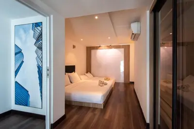 a bedroom with a white bed and a large window at XBox, Karaoke, Foosball, PoolTable, IceHockey, Ping Pong, Board Games in George Town