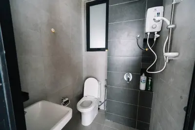 a bathroom with a toilet and a sink and a mirror at NEW Infinity Pool Seaview 3Bedrooms 2Carparks 262 in Jelutong