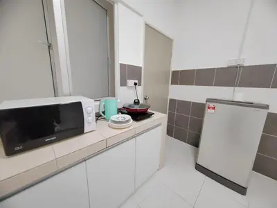 a small kitchen with a microwave on a counter at Muji Style brick themed Cameron Highland Homestay FREE Netflix in Tanah Rata