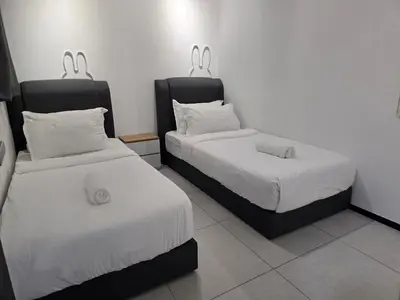a room with two beds with white sheets at Vanilla Cottage - Urban Suites by Ocean Luxe in Jelutong