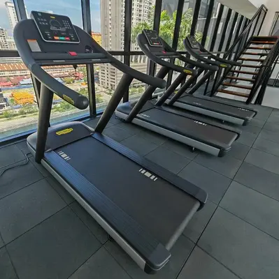 a row of treadmills in a gym next to a window at Vanilla Cottage - Urban Suites by Ocean Luxe in Jelutong
