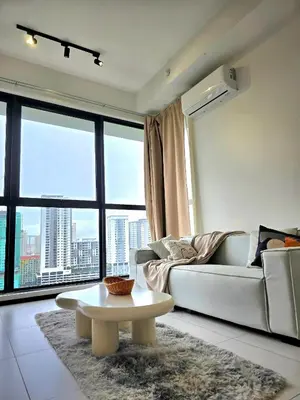 a living room with a couch and a table in front of a window at Vanilla Cottage - Urban Suites by Ocean Luxe in Jelutong