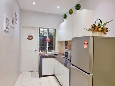 a kitchen with white cabinets and a refrigerator at Sunway Cozy Apartment near Lost World of Tambun in Ipoh