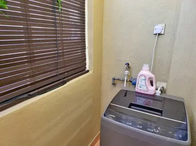 a washing machine with a pink bottle on top of it at Sunway Cozy Apartment near Lost World of Tambun in Ipoh