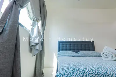 a bedroom with a blue bed with a window at Cozy&Comfy Suite Room Perai in Perai