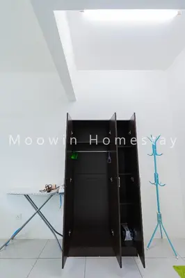 a black cabinet with a sign on it next to a table at Cozy&Comfy Suite Room Perai in Perai