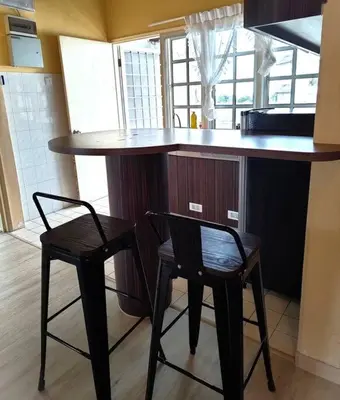 a kitchen with two bar stools and a kitchen counter at Silverpart Resort Fraser Hill B5-6-1 Forest View High Floor No lift in Bukit Fraser