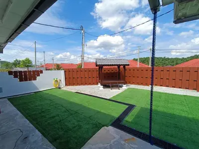 a backyard with a artificial lawn and a fence at Home MH Casa Damai Private Pool at Sungai Petani in Sungai Petani