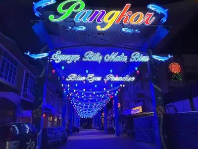 a neon sign on a city street at night at Pangkor BeachWalk Studio in Pangkor