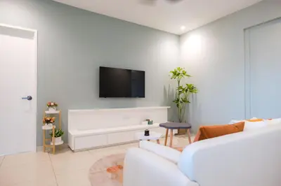 a white living room with a white couch and a tv at Zenstay Abnb Perai Penang in Bukit Mertajam