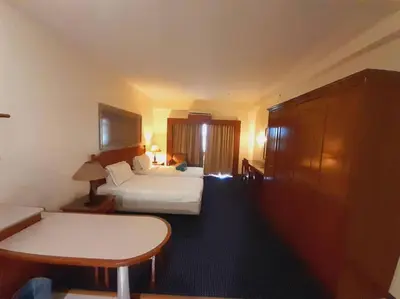 a hotel room with two beds and a table at Rainbow Paradise Homestay @ Tanjung Bungah by Landmark in Tanjung Bungah